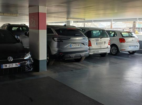 Emplacements de stationnement couverts et éclairés au niveau 2a du parking.