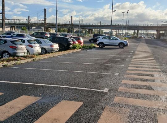 Allée de circulation et passage piéton desservant les places de stationnement extérieures.