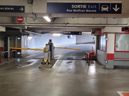 Voie de sortie réservée aux véhicules équipée d'une borne de validation et d'une barrière levante automatique.