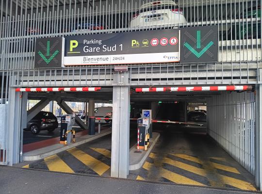 Entrée du parking couvert Gare Sud 1 avec barrières automatiques et affichage dynamique des places.