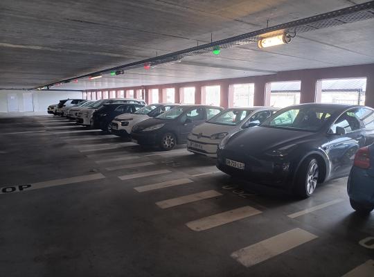 Rangée de places de stationnement couvertes avec système de guidage lumineux à la place.