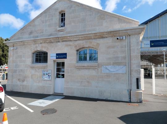 Bâtiment d'accueil du parking EFFIA en pierre de taille, situé à proximité immédiate du hall de la gare.