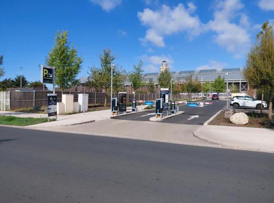 Entrée du parking extérieur P2 avec bornes de contrôle à tickets et barrières automatiques, située face à la gare.