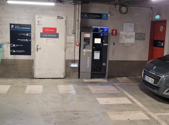 Caisse automatique de paiement installée dans la zone de circulation près de la porte d'accès technique.