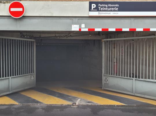 Portail automatique métallique ouvert à l'entrée du parking réservé aux abonnés Teinturerie.