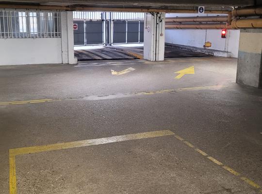 Zone de passage intérieure équipée d'une borne de contrôle lumineuse et de potelets de signalisation jaunes.