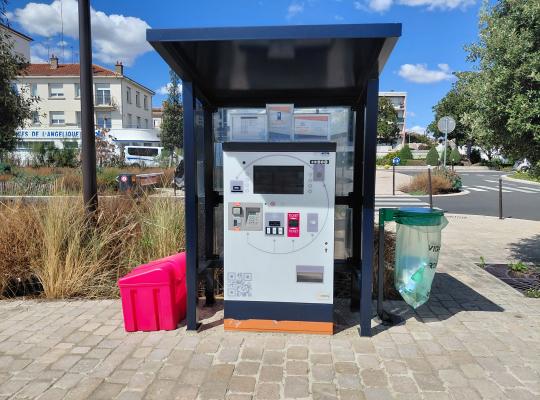 Borne de paiement automatique du parking installée sous un abri vitré protecteur.