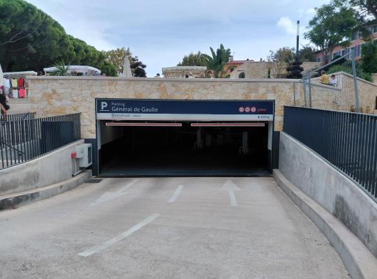Rampe d'accès extérieure menant à l'entrée couverte du parking Général de Gaulle sous une structure en pierre.