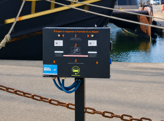 Borne de recharge pour véhicules électriques EFFIA installée sur le quai près des embarcations.