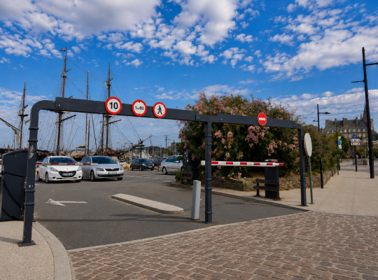 Portique de gabarit et barrière d'accès contrôlant l'entrée du parking.