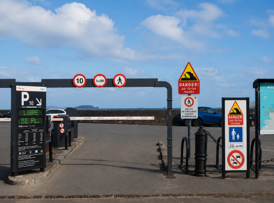 Entrée du parking P10 avec panneau d'affichage des places disponibles et signalétique de danger de fortes marées.