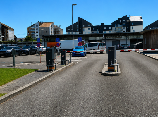 Accès au parking de la gare avec totem des tarifs EFFIA, bornes de contrôle et barrières levantes.