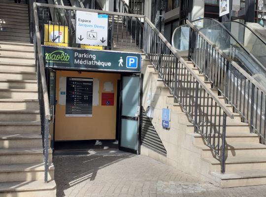 Entrée piétonne du Parking Médiathèque encadrée par des escaliers et un escalier mécanique menant à l'Espace Jacques Demy.