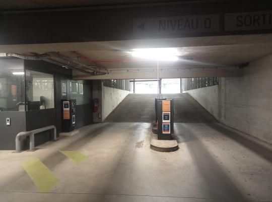 Rampes d'accès et de sortie d'un parking couert équipées de bornes de péage et d'un poste de contrôle.