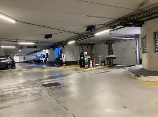 Zone de sortie intérieure dotée de bornes de validation, d'une barrière levante et d'une porte de garage automatique.