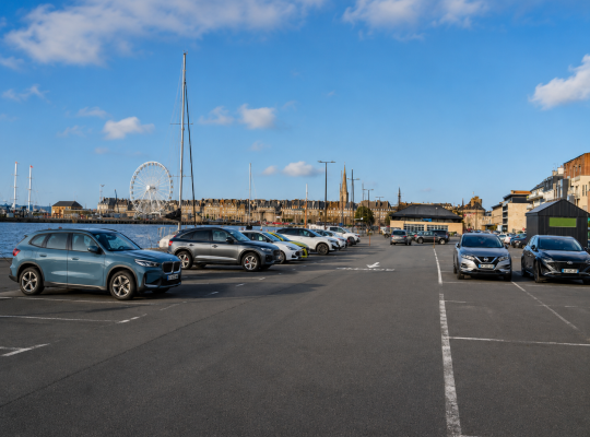 Emplacements de stationnement sur le quai avec vue sur le bassin, la grande roue et les remparts.