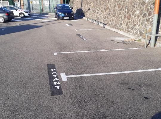 Places de stationnement extérieures marquées au sol de la mention payant.
