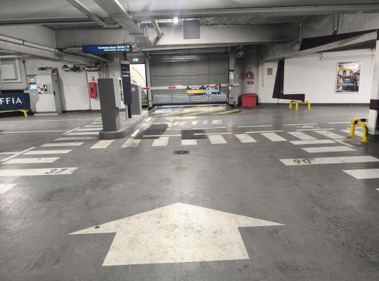 Zone de sortie du parking couvert comprenant la barrière automatique, la borne à cartes et la caisse automatique.