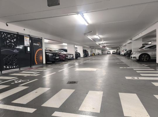 Emplacements de stationnement numérotés dans un parking souterrain éclairé, à côté d'un local sécurisé EFFIA Bike.