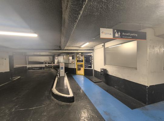 Zone d'accueil EFFIA et barrière de sortie automatique situées à l'intérieur du parking couvert.