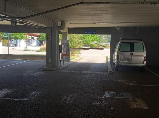 Voie de sortie intérieure du parking couverte donnant sur l'extérieur avec barrière automatique.