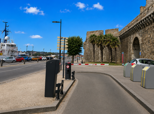 Sortie du parking avec barrière automatique, située entre les remparts historiques et le bassin portuaire.
