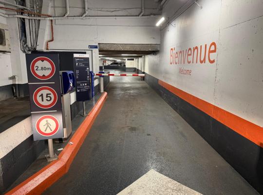 Borne de contrôle avec barrière levante, panneau d'affichage des tarifs EFFIA et inscription « Bienvenue » sur le mur.