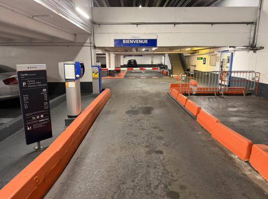 Borne d'accès avec ticket, totem tarifaire EFFIA et panneau « Bienvenue » à l'entrée du parking Piscine / Patinoire.