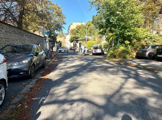 Voie de circulation du parking extérieur menant vers la barrière de sortie et la rue adjacente.