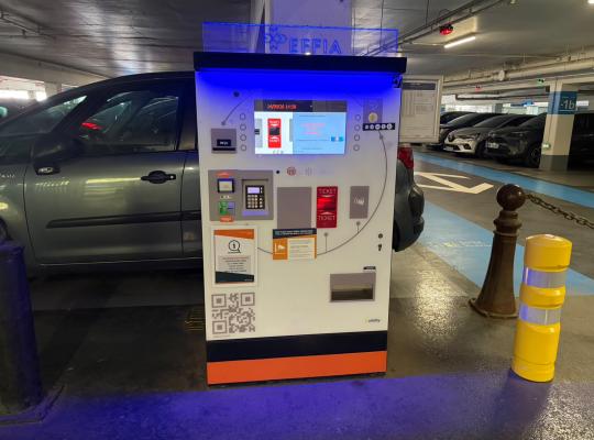 Caisse automatique de paiement EFFIA équipée d'un écran tactile, d'un terminal bancaire et d'un affichage tarifaire en sous-sol.