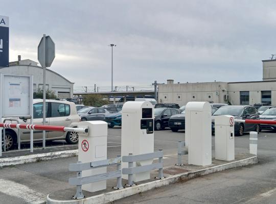 Voies d'accès au parking de la gare avec bornes et barrières automatiques.