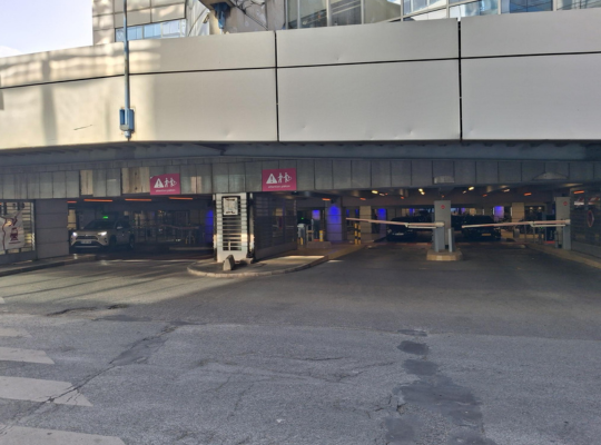Vue des voies de sortie du parking sous structure couverte, équipées de barrières automatiques.