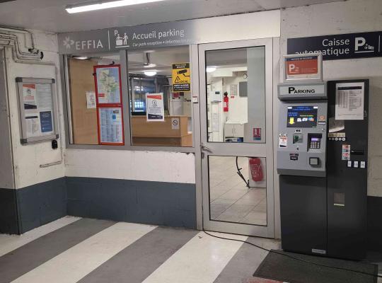 Guichet d'accueil du parking EFFIA à côté d'une caisse automatique.