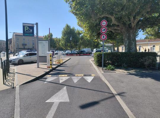 Voie d'accès au parking P2 avec ralentisseur, bornes et panneaux de signalisation.