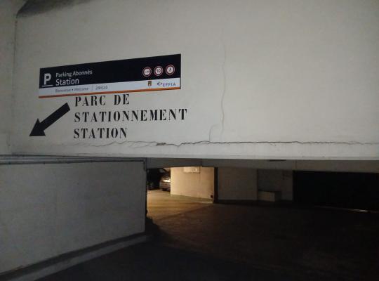 Entrée du parking abonnés Station avec flèche de direction et signalisation EFFIA.