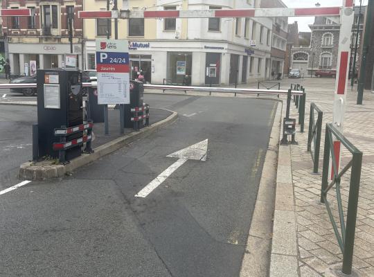 Voie d'entrée du parking Jaurès avec barrière, borne et panneau de tarifs.