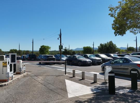 Voie d'accès d'un parking extérieur avec barrière automatique et affichage « LIBRE