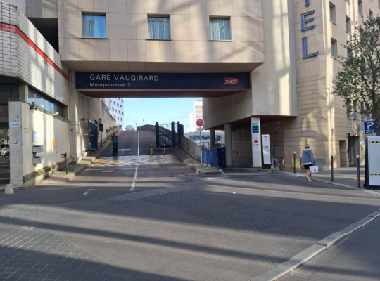 Vue extérieure montrant l'accès à la gare Vaugirard (Montparnasse 3) sous un bâtiment.