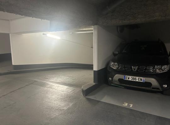 Véhicule garé sur un emplacement numéroté près d'un virage en sous-sol.