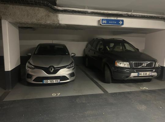 Voitures stationnées sur des places numérotées dans un parking souterrain.