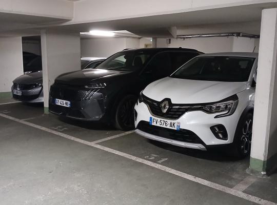 Voitures garées sur des emplacements numérotés dans un parking souterrain.