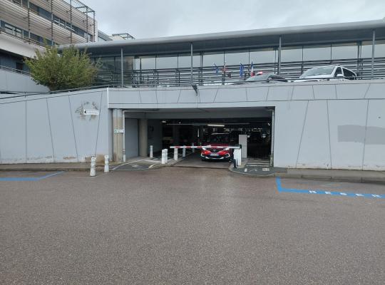 Voie de sortie du parking P5 sous un bâtiment avec une barrière de contrôle.